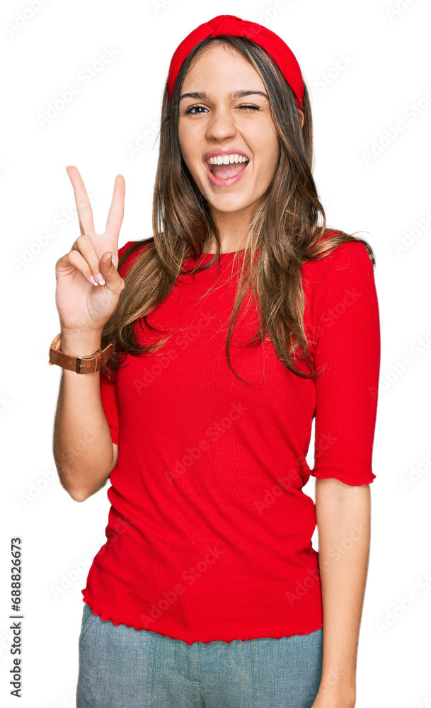 Young brunette woman wearing casual clothes smiling with happy face winking at the camera doing victory sign with fingers. number two. Young brunette woman wearing casual clothes smiling with happy face winking at the camera doing victory sign with fingers. number two.