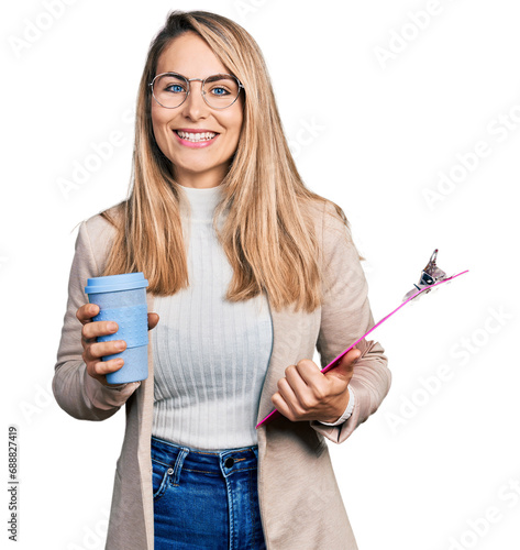 Young blonde woman wearing business style  drinking coffee and holding clipboard smiling with a happy and cool smile on face. showing teeth.