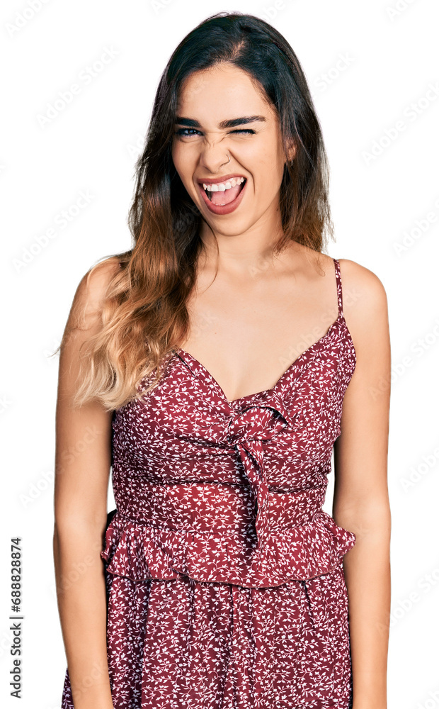 Beautiful hispanic woman wearing summer dress winking looking at the camera with sexy expression, cheerful and happy face. Beautiful hispanic woman wearing summer dress winking looking at the camera with sexy expression, cheerful and happy face.