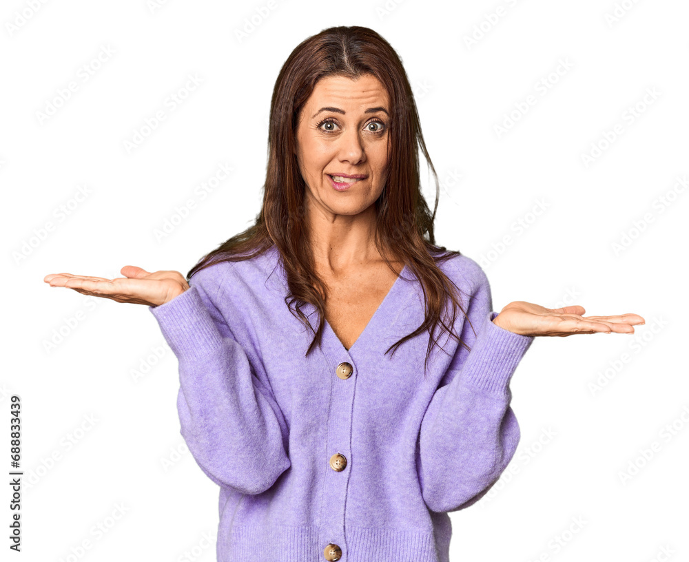 Elegant middle-aged Caucasian woman in studio setting confused and doubtful shrugging shoulders to hold a copy space. Elegant middle-aged Caucasian woman in studio setting confused and doubtful shrugging shoulders to hold a copy space.
