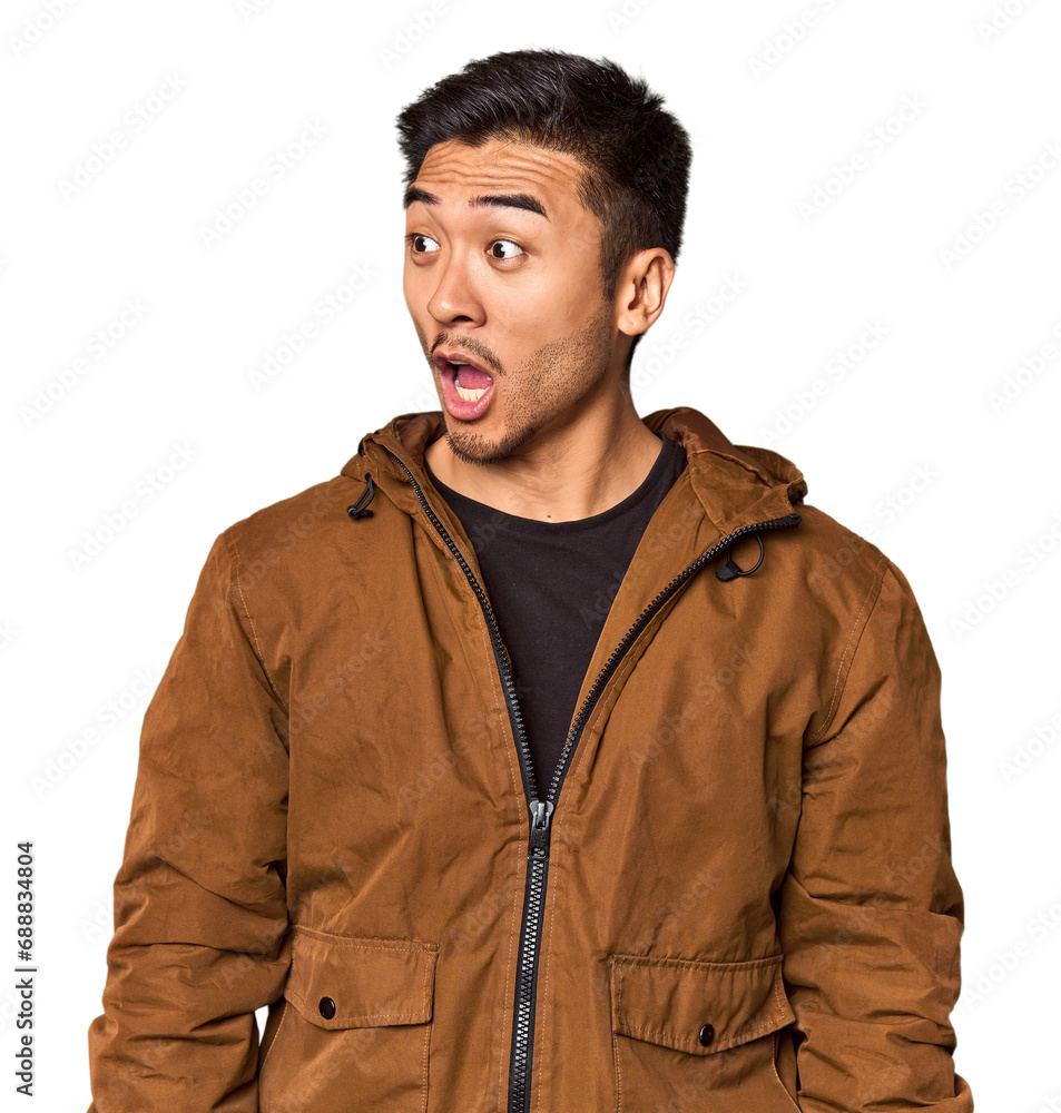 Young Chinese man in studio background being shocked because of something she has seen. Young Chinese man in studio background being shocked because of something she has seen.