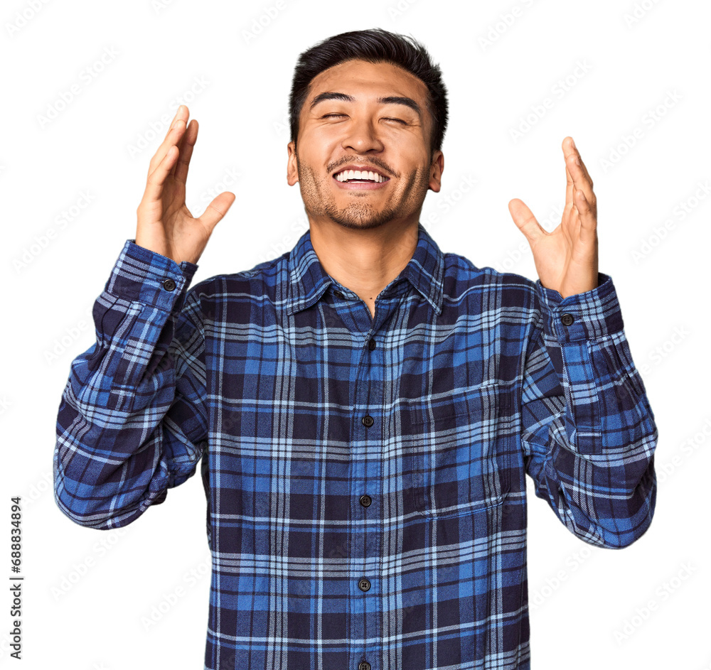 Young Chinese man in studio background joyful laughing a lot. Happiness concept. Young Chinese man in studio background joyful laughing a lot. Happiness concept.
