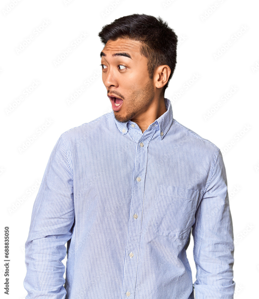 Young Chinese man in studio background being shocked because of something she has seen. Young Chinese man in studio background being shocked because of something she has seen.