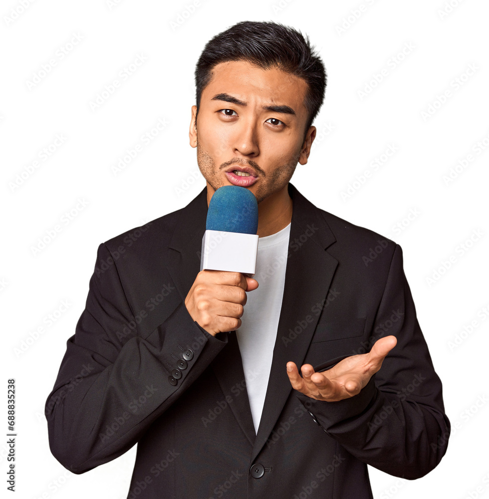 Young Chinese TV presenter reporting news with microphone in studio Young Chinese TV presenter reporting news with microphone in studio