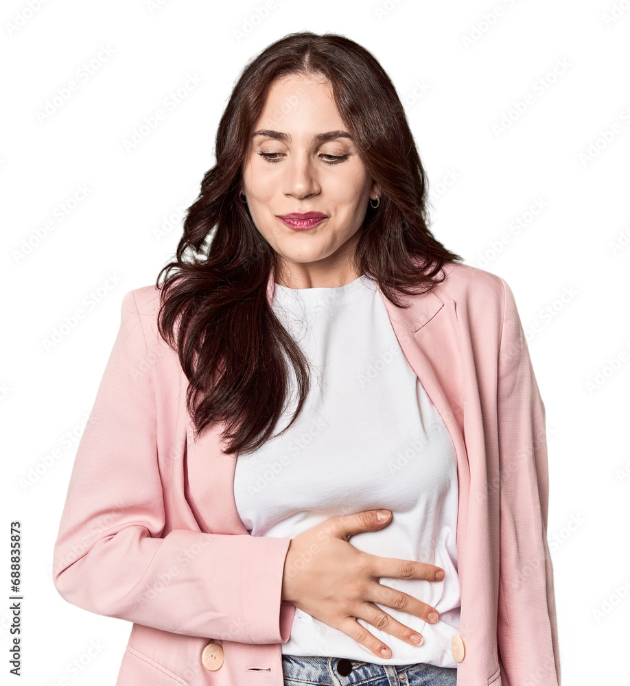 Young Caucasian woman in a studio setting touches tummy, smiles gently, eating and satisfaction concept. Young Caucasian woman in a studio setting touches tummy, smiles gently, eating and satisfaction concept.