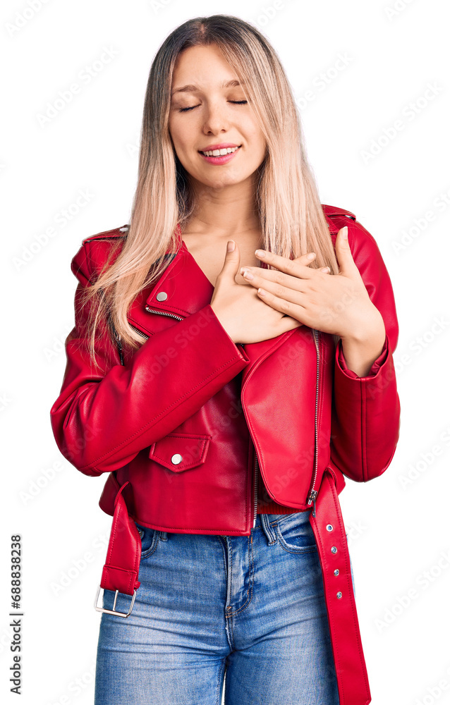 Young beautiful blonde woman wearing red leather jacket smiling with hands on chest with closed eyes and grateful gesture on face. health concept. Young beautiful blonde woman wearing red leather jacket smiling with hands on chest with closed eyes and grateful gesture on face. health concept.
