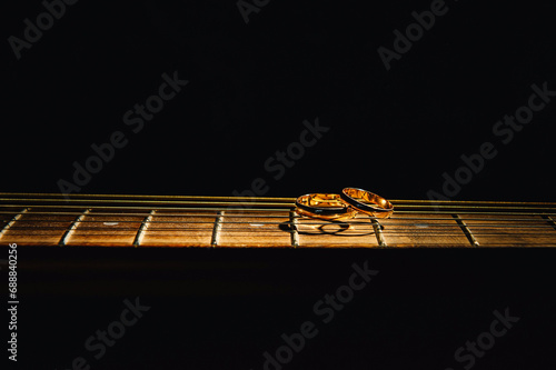 Rings lying on guitar strings against a black background