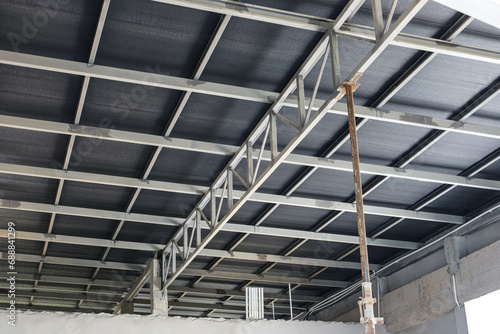 Structure of the steel roof frame. Close up of detail of metal roof structure of building or house with temporary support pillars with copy space and selective focus.