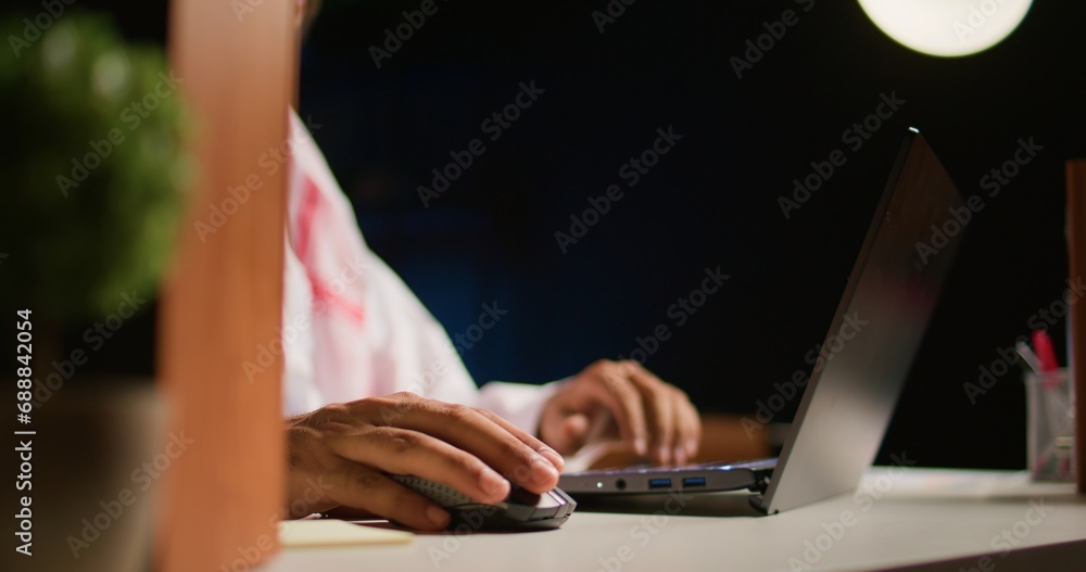 Fototapeta premium Close up shot of hardworking businessman using laptop keyboard and mouse at office desk to surf the internet. Company executive typing on digital device, finishing tedious paperwork