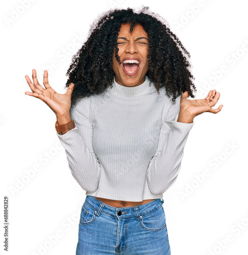 Young african american girl wearing casual clothes crazy and mad shouting and yelling with aggressive expression and arms raised. frustration concept.