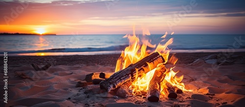 Empty beach bonfire with stunning sunrise/set in focus, devoid of individuals.