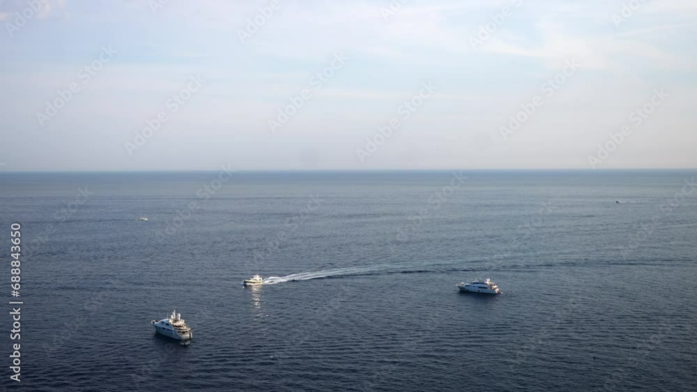 Top view from Amalfi coast to boat and yachts sailing in Mediterranean sea on background of beautiful seascape and skyline on summer day. Many boats ships moving in distance, slow motion. Top view from Amalfi coast to boat and yachts sailing in Mediterranean sea on background of beautiful seascape and skyline on summer day. Many boats ships moving in distance, slow motion.