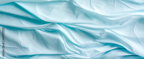 Closeup of rippled light blue silk fabric cloth texture background
