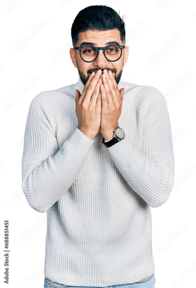 Young arab man with beard wearing elegant turtleneck sweater and glasses laughing and embarrassed giggle covering mouth with hands, gossip and scandal concept Young arab man with beard wearing elegant turtleneck sweater and glasses laughing and embarrassed giggle covering mouth with hands, gossip and scandal concept