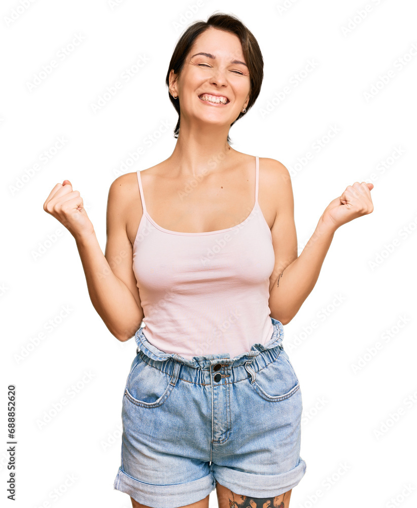 Young brunette woman with short hair wearing casual summer clothes very happy and excited doing winner gesture with arms raised, smiling and screaming for success. celebration concept. Young brunette woman with short hair wearing casual summer clothes very happy and excited doing winner gesture with arms raised, smiling and screaming for success. celebration concept.