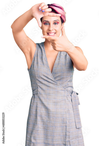 Young beautiful woman with pink hair wearing casual clothes smiling making frame with hands and fingers with happy face. creativity and photography concept.