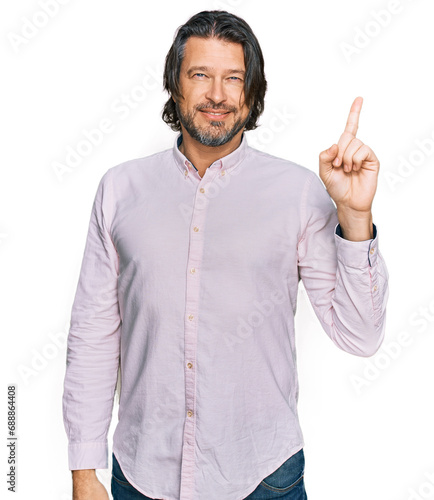 Middle age handsome man wearing business shirt showing and pointing up with finger number one while smiling confident and happy. © Krakenimages.com
