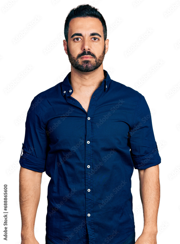 Young hispanic man with beard wearing casual blue shirt with serious expression on face. simple and natural looking at the camera.