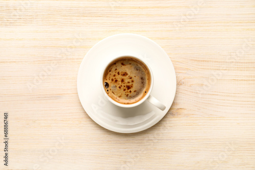 Cup of hot coffee on wooden table, top view