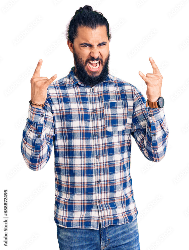 Young arab man wearing casual clothes shouting with crazy expression doing rock symbol with hands up. music star. heavy concept. Young arab man wearing casual clothes shouting with crazy expression doing rock symbol with hands up. music star. heavy concept.