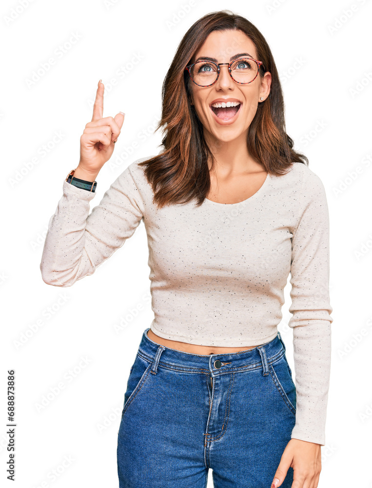 Young brunette woman wearing casual clothes and glasses pointing finger up with successful idea. exited and happy. number one. Young brunette woman wearing casual clothes and glasses pointing finger up with successful idea. exited and happy. number one.