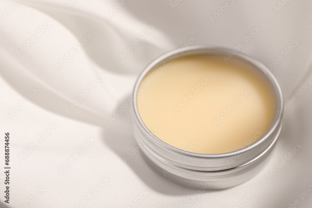 Lip balm on white fabric, closeup. Space for text Lip balm on white fabric, closeup. Space for text
