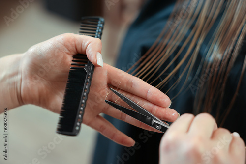 Professional hairdresser cutting girl s hair in beauty salon  closeup