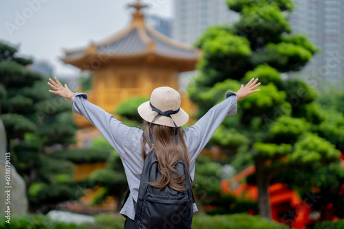 Asian tourist, cute woman with long hair are traveling in Hong Kong along with map and her camera with fun on her holiday, A temple in Hong Kong, concept travel, Nan Lian garden, Chinese classical. 