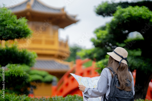 Canvas Print Asian tourist, cute woman with long hair are traveling in Hong Kong along with map and her camera with fun on her holiday, A temple in Hong Kong, concept travel, Nan Lian garden, Chinese classical