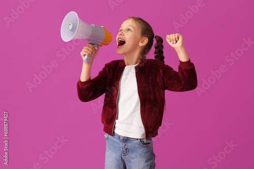 Little girl with megaphone screaming on purple background