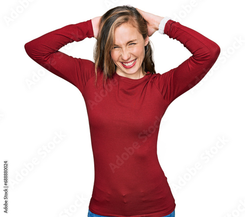 Young blonde woman wearing casual clothes relaxing and stretching, arms and hands behind head and neck smiling happy © Krakenimages.com