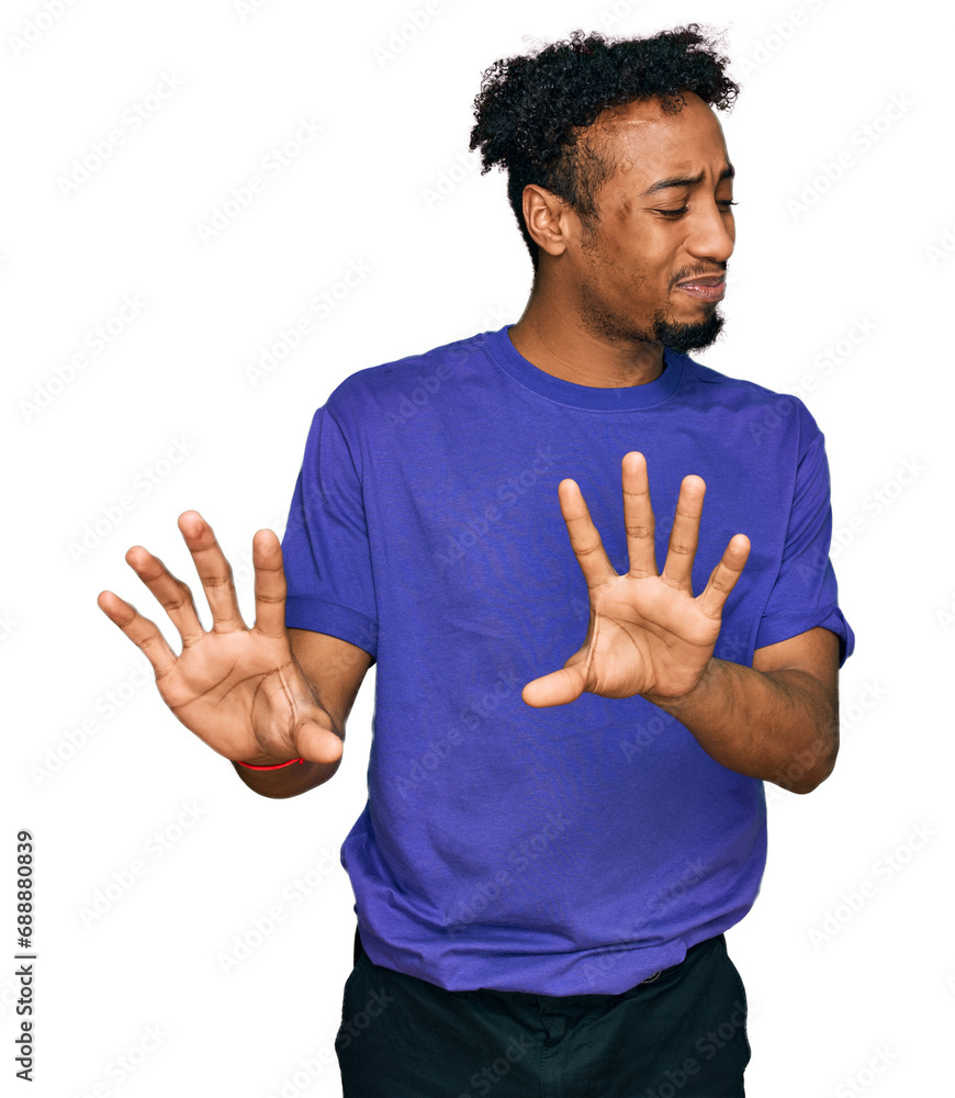 Young african american man with beard wearing casual purple t shirt disgusted expression, displeased and fearful doing disgust face because aversion reaction. with hands raised Young african american man with beard wearing casual purple t shirt disgusted expression, displeased and fearful doing disgust face because aversion reaction. with hands raised