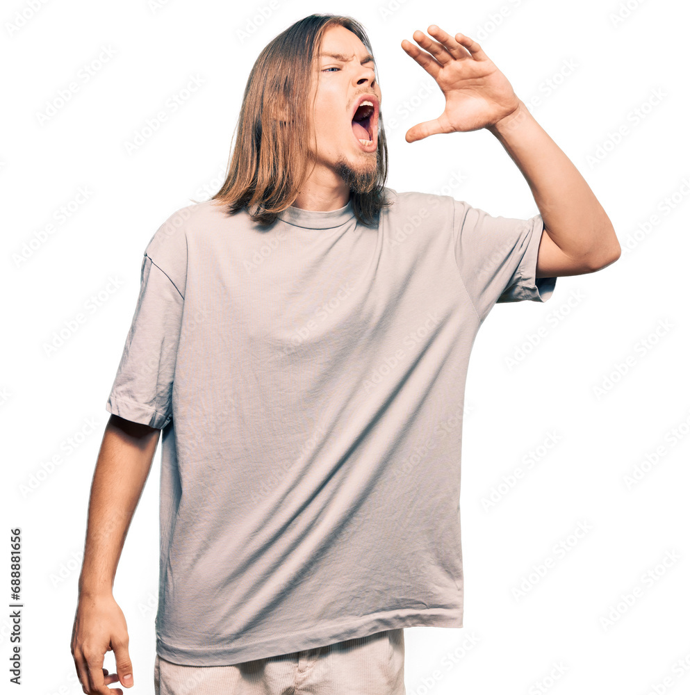 Handsome caucasian man with long hair wearing casual clothes shouting and screaming loud to side with hand on mouth. communication concept. Handsome caucasian man with long hair wearing casual clothes shouting and screaming loud to side with hand on mouth. communication concept.