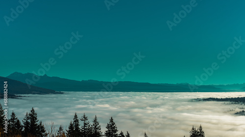 Cloud inversion over Fraser Valley, BC, with mountains in silhouette oh horizon, as viewed from Burnaby Mountain, BC.