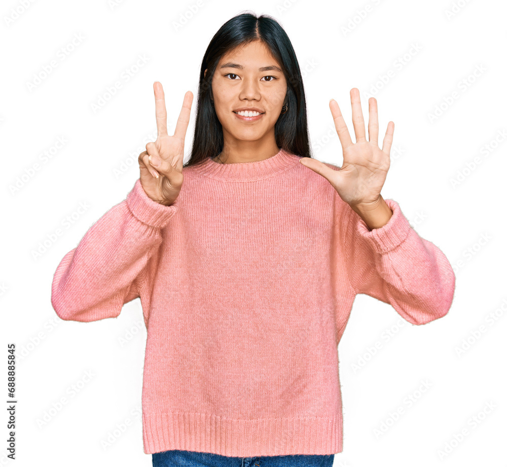 Beautiful young asian woman wearing casual winter sweater showing and pointing up with fingers number seven while smiling confident and happy. Beautiful young asian woman wearing casual winter sweater showing and pointing up with fingers number seven while smiling confident and happy.