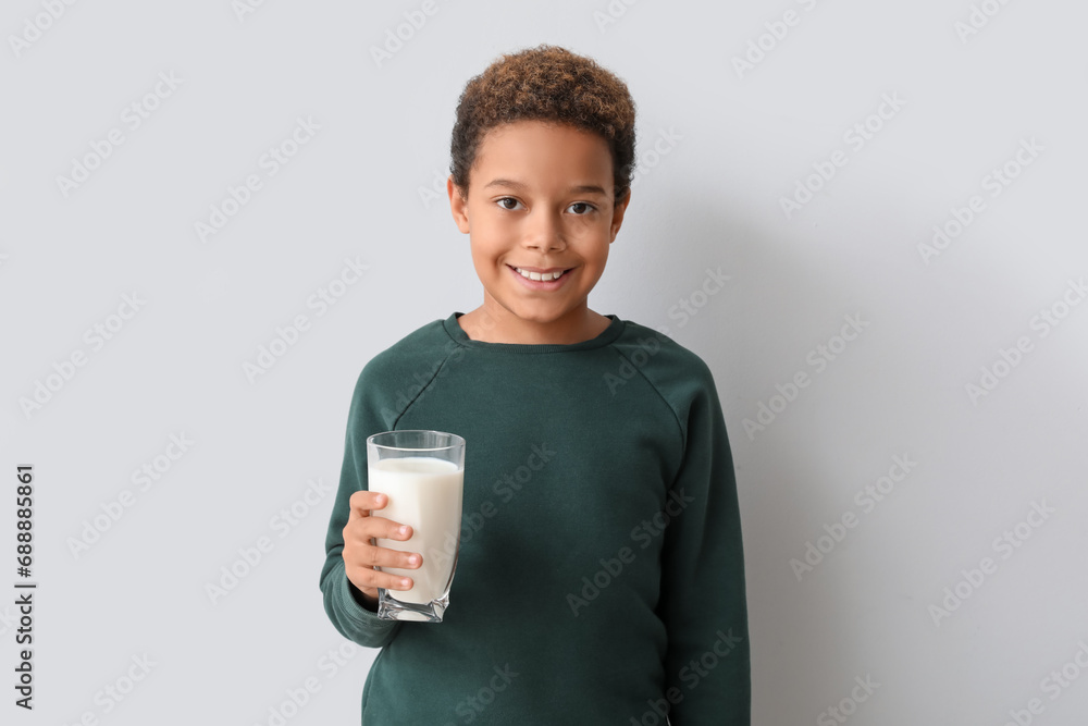 Little African-American boy with glass of milk on white background Little African-American boy with glass of milk on white background