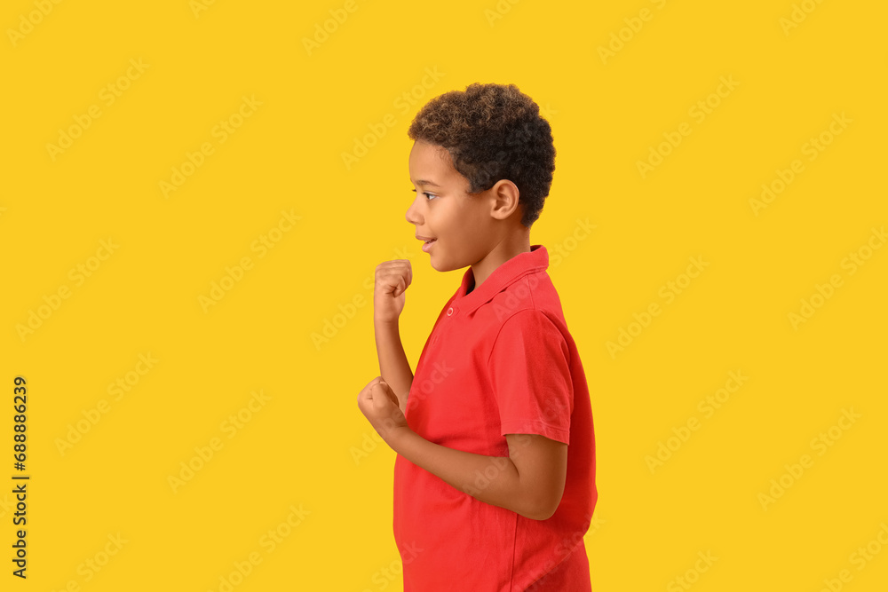Little African-American boy on yellow background Little African-American boy on yellow background