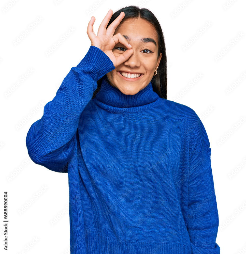 Young asian woman wearing casual winter sweater smiling happy doing ok sign with hand on eye looking through fingers Young asian woman wearing casual winter sweater smiling happy doing ok sign with hand on eye looking through fingers