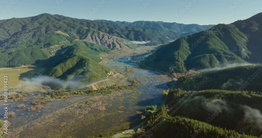 Reverse aerial flight of Te Paranui wetland ecosystem within wild, rugged and mountainous landscape in South Island of New Zealand Aotearoa Reverse aerial flight of Te Paranui wetland ecosystem within wild, rugged and mountainous landscape in South Island of New Zealand Aotearoa