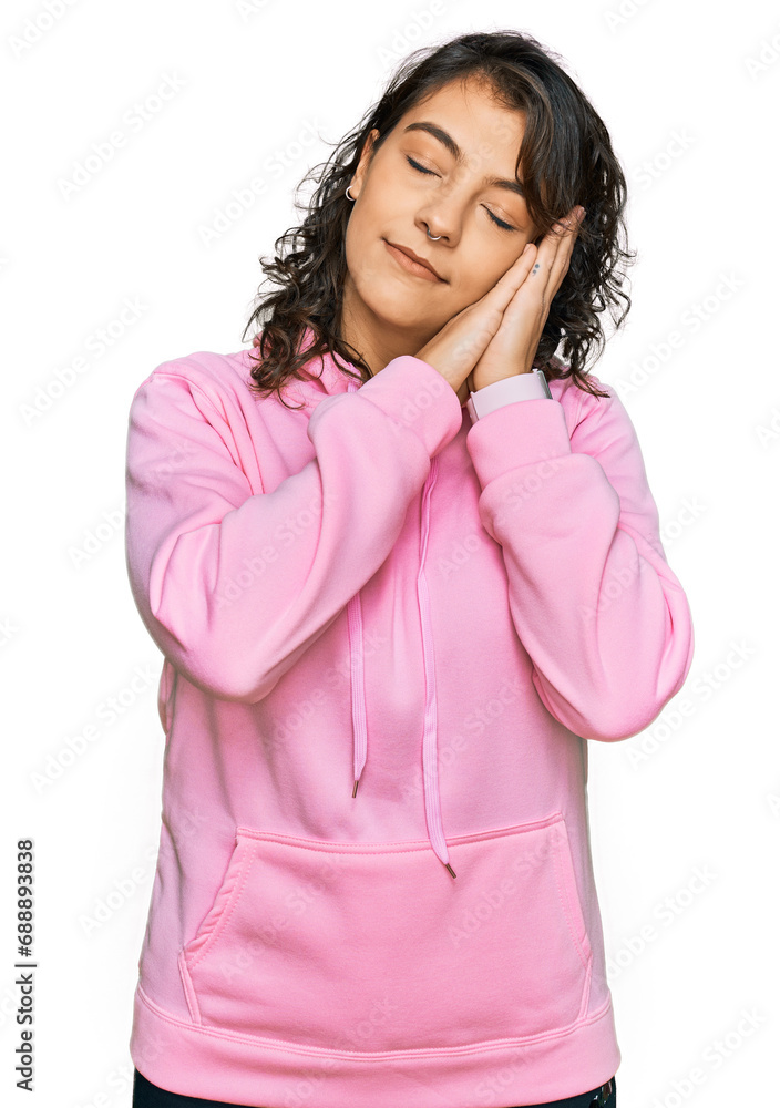Young hispanic woman wearing casual sweatshirt sleeping tired dreaming and posing with hands together while smiling with closed eyes. Young hispanic woman wearing casual sweatshirt sleeping tired dreaming and posing with hands together while smiling with closed eyes.