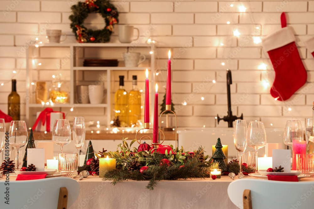 Festive table setting with Christmas decorations and glowing lights in kitchen at evening - obrazy, fototapety, plakaty 