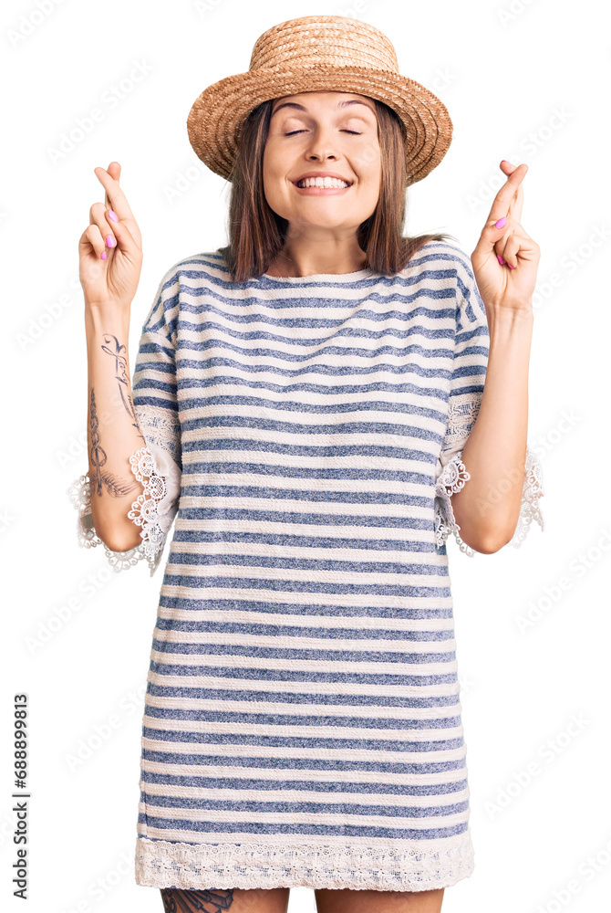 Beautiful caucasian woman wearing summer hat gesturing finger crossed smiling with hope and eyes closed. luck and superstitious concept. Beautiful caucasian woman wearing summer hat gesturing finger crossed smiling with hope and eyes closed. luck and superstitious concept.