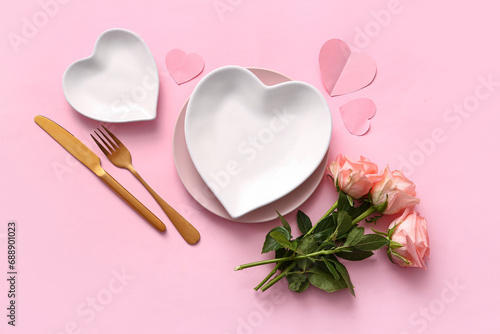 Beautiful table setting with roses for Valentine's Day on pink background photo
