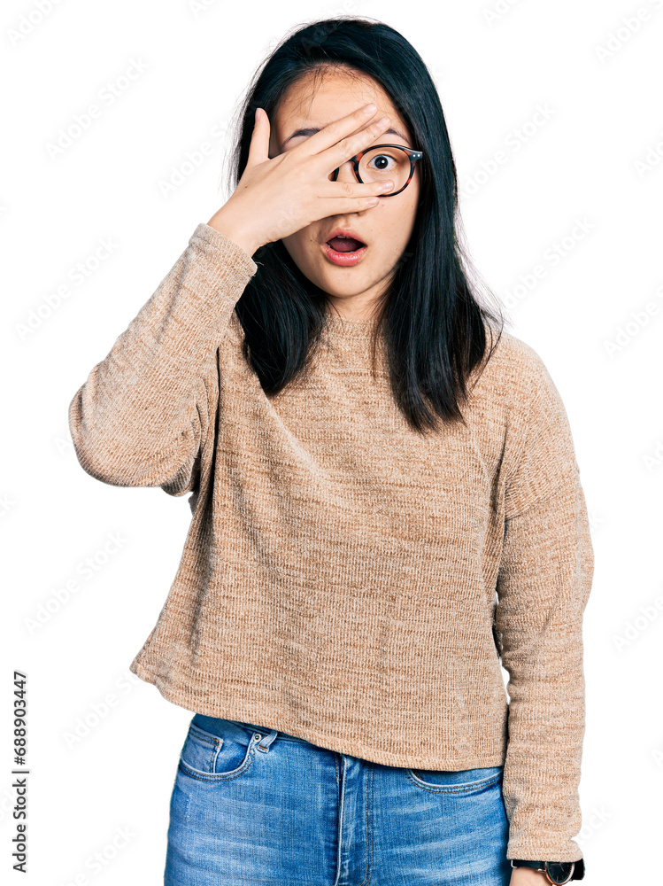 Young chinese woman wearing casual sweater and glasses peeking in shock covering face and eyes with hand, looking through fingers with embarrassed expression. Young chinese woman wearing casual sweater and glasses peeking in shock covering face and eyes with hand, looking through fingers with embarrassed expression.