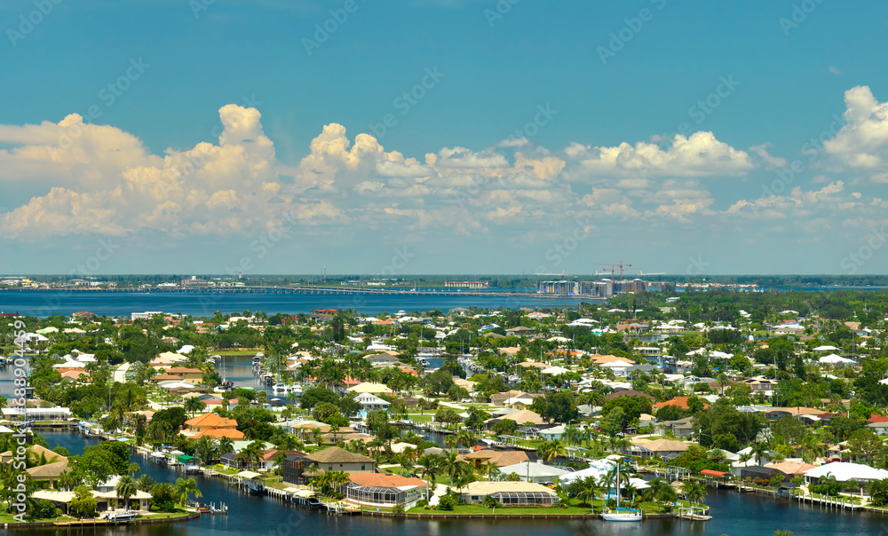 Aerial view of residential suburbs with private homes located on gulf coast near wildlife wetlands with green vegetation on sea shore. Living close to nature concept