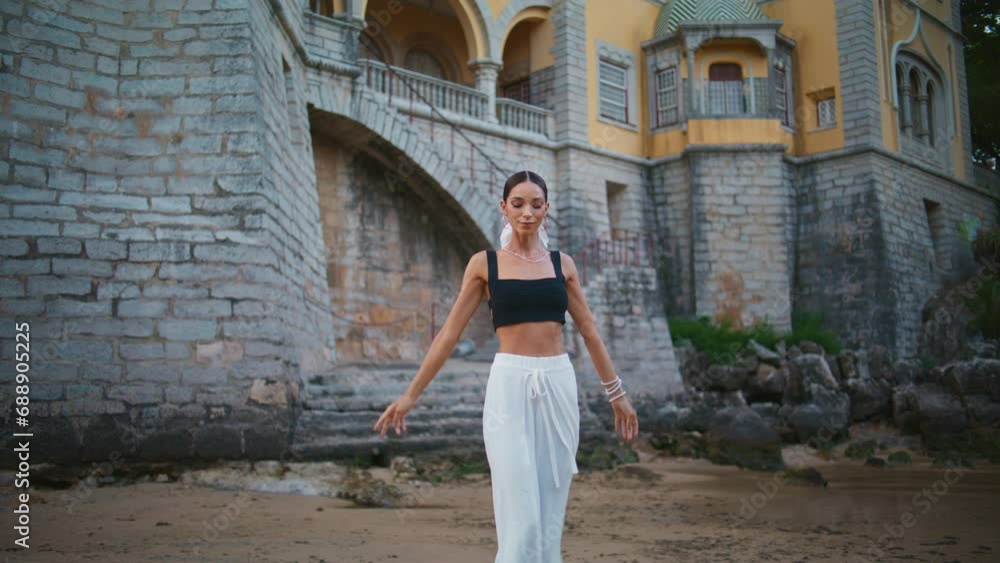 Attractive tourist posing beautiful castle raising hands. Elegant woman traveler Attractive tourist posing beautiful castle raising hands. Elegant woman traveler