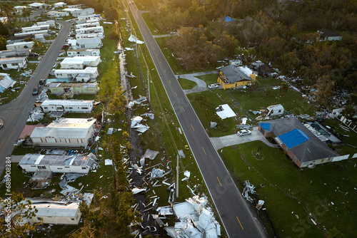 Severely damaged by hurricane Ian houses in Florida mobile home residential area. Consequences of natural disaster photo