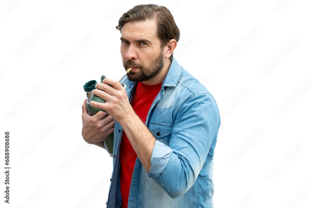 Young man drinking mate, holding the thermos in one arm. Young man drinking mate, holding the thermos in one arm.