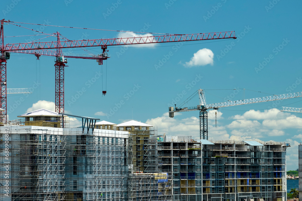 Tower lifting cranes at high residential apartment buildings construction site. Real estate development Tower lifting cranes at high residential apartment buildings construction site. Real estate development