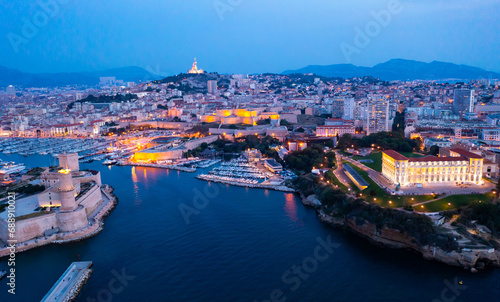 Bir's eye view of Marseille in evening with turned on city lights. Palais du Pharo visible from above.